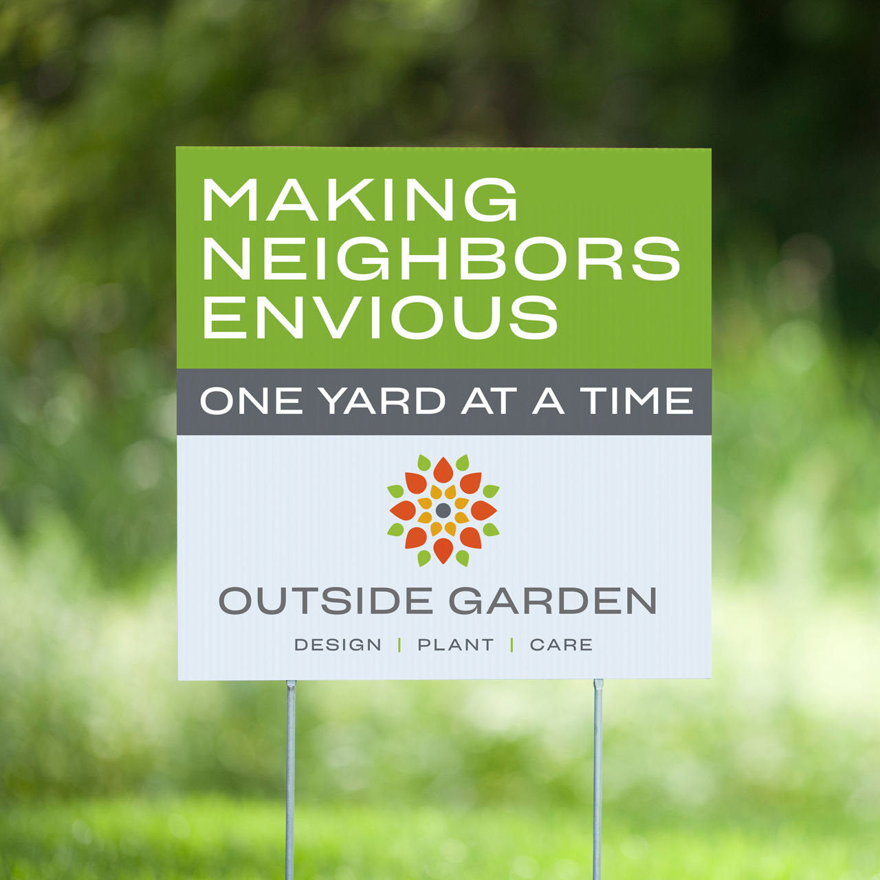 An image of the yard sign for Outside Garden that reads "Making Neighbors Envious One Yard at a Time"