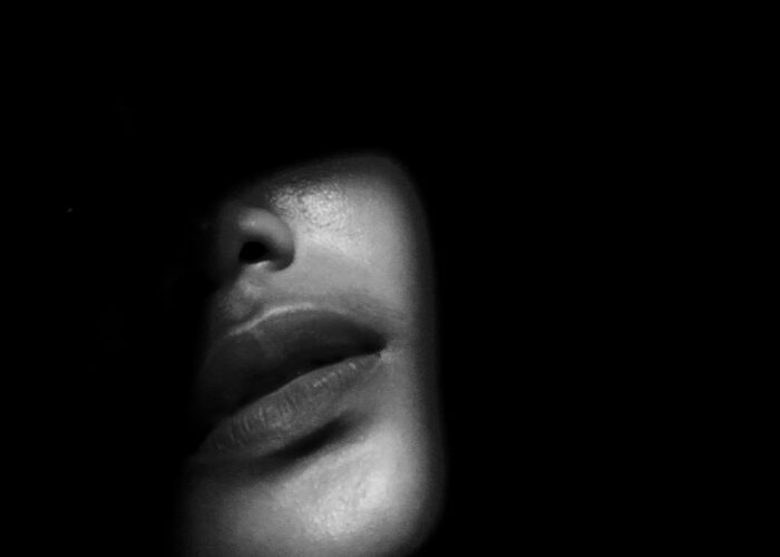 A dark moody image of a woman's face